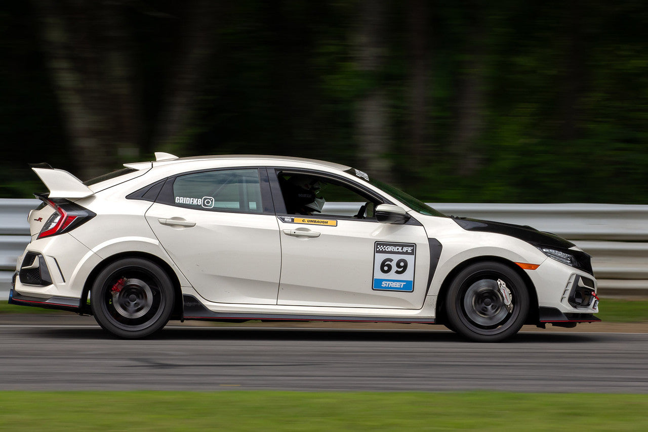champ white civic type r racing on racetrack